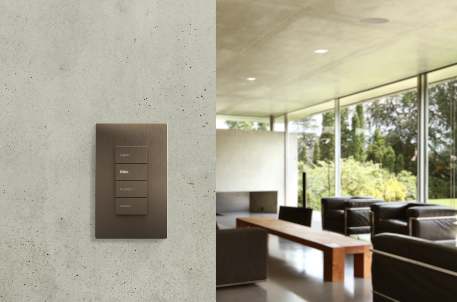 A modern smart lighting control panel with a sleek metallic finish is mounted on a textured concrete wall. The panel includes labeled buttons for various lighting scenes, such as "Relax" and "Daylight."