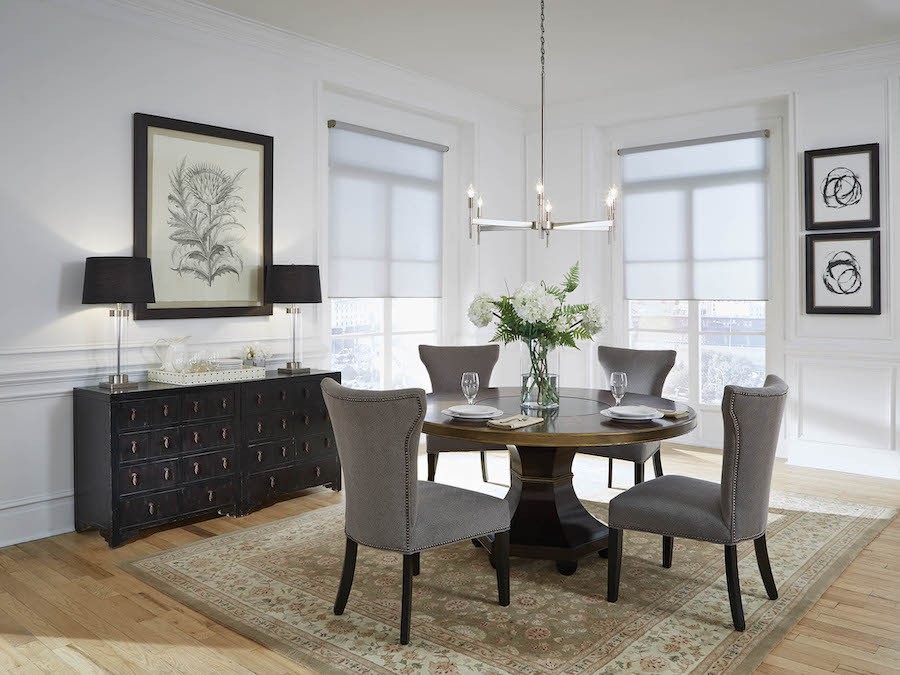 Lutron motorized shades letting natural light into an elegant dining room.