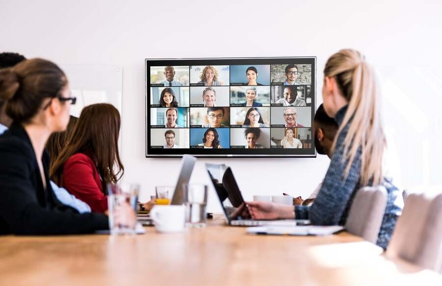 A group of people in a meeting with a remote team.