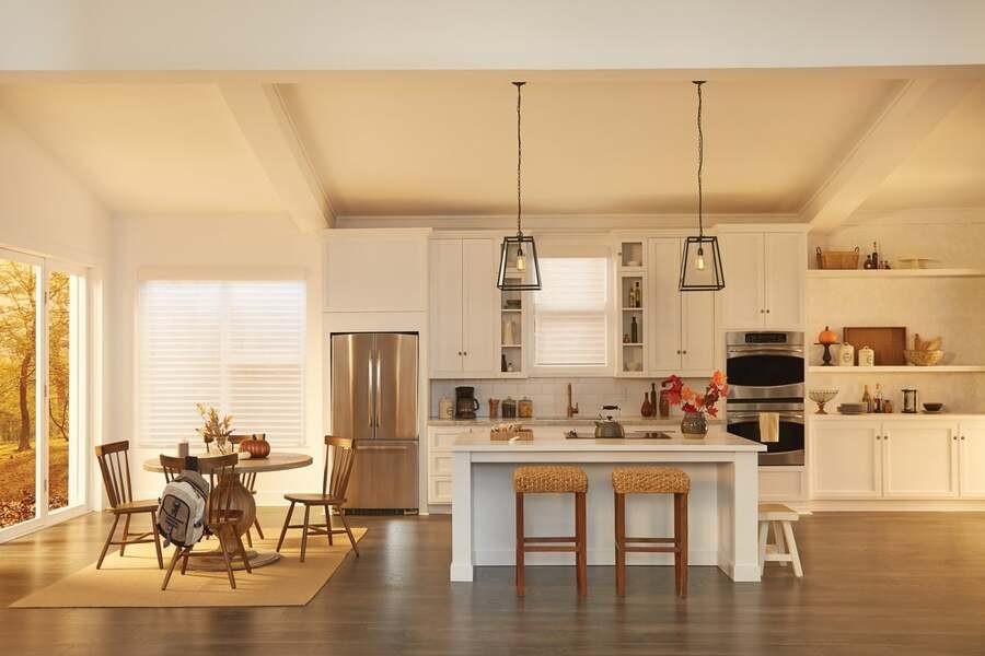 A beautiful kitchen on a fall afternoon with Lutron motorized shades on the windows.