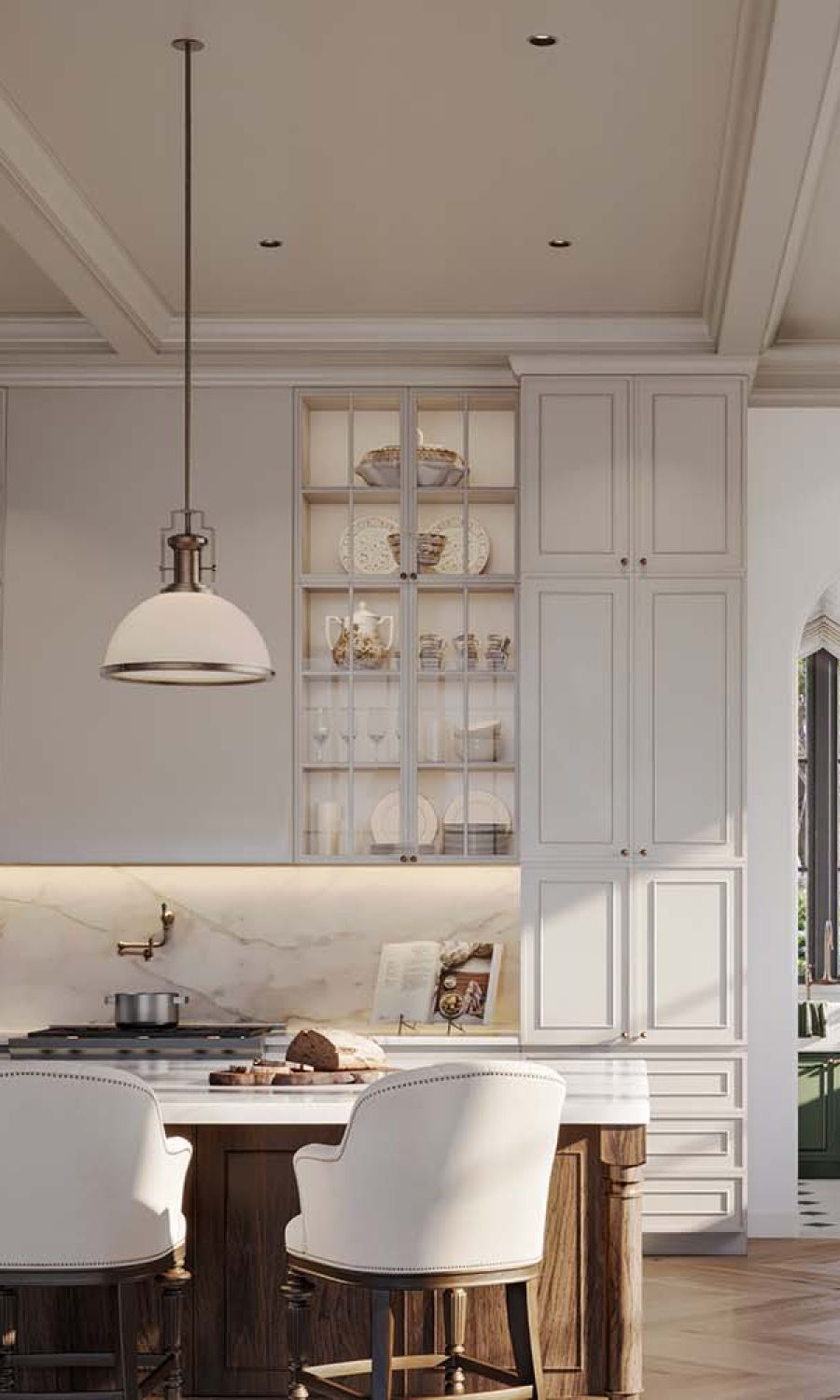 Elegant kitchen with glass-front cabinets displaying dishes, a marble backsplash, a pendant light over a wood island, and two white upholstered counter chairs with bread and a cookbook on the countertop.
